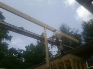 Carpenter setting a ridge beam over a new addition frame — Ice Dam Removal by Roofing Brothers in Fallston