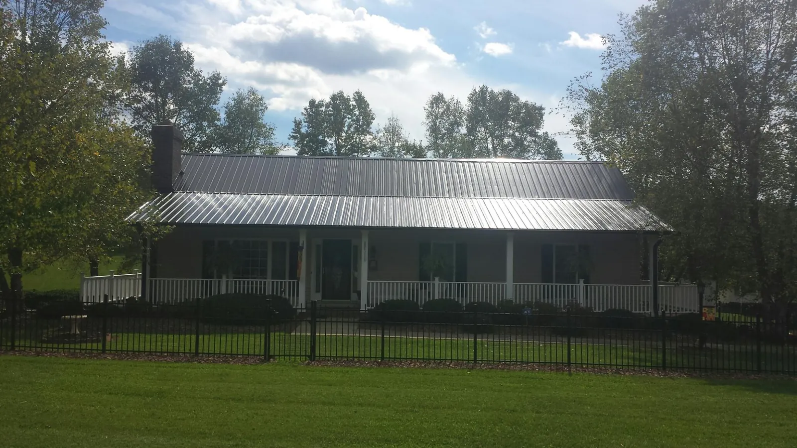 Gray metal roof on a brick ranch with a full width front porch — Gutter Guard Installation work by our crew in Fallston
